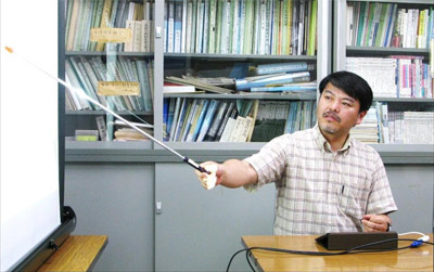 アイパッドの情報をスクリーンに映し出して説明する飯塚直也先生